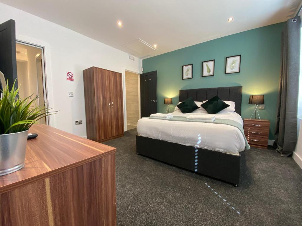 利物浦Modern 3 bedroom apartment close to the city centre的一间卧室配有一张大床和一个木制梳妆台