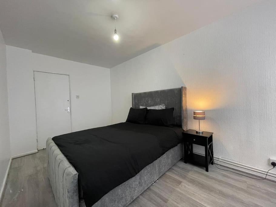 WoolwichXtra large 1 bedroom London Flat的一间卧室配有一张床和一张桌子上的台灯