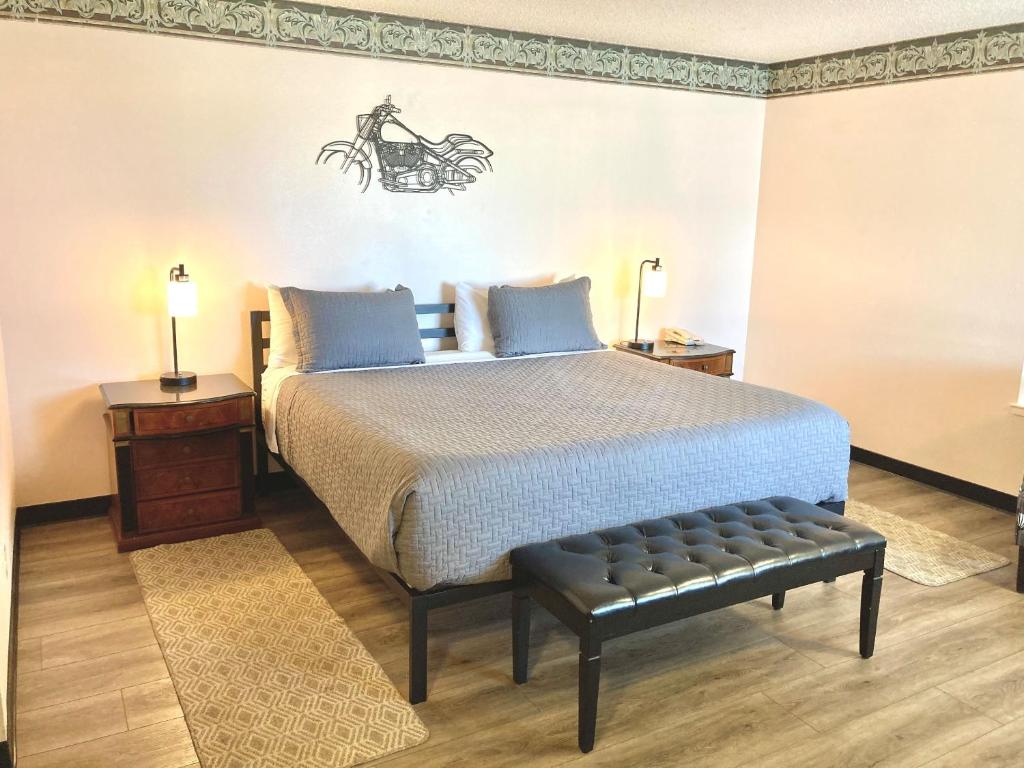 圣西米恩Coast Riders Inn的一间卧室配有一张床,旁边设有长凳