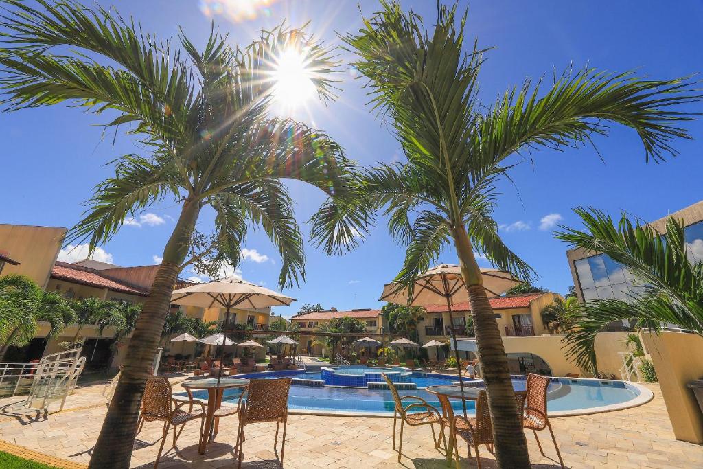 皮帕Solar Água Pipa- Summer Pipa的一个带游泳池、棕榈树和椅子的度假酒店
