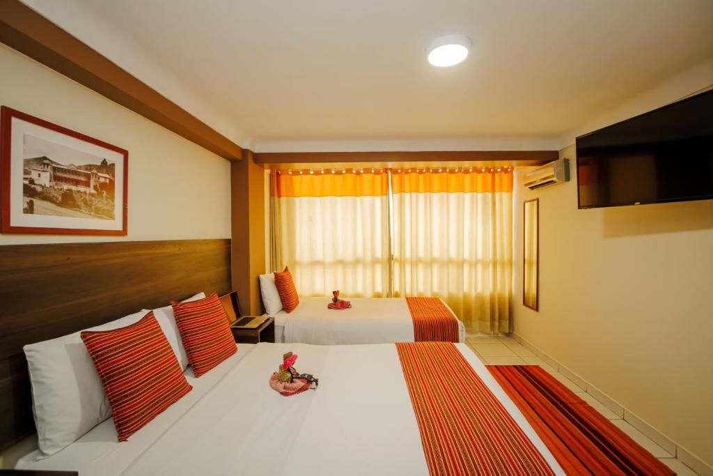 库斯科普林西比三世酒店的酒店客房设有两张床和电视。