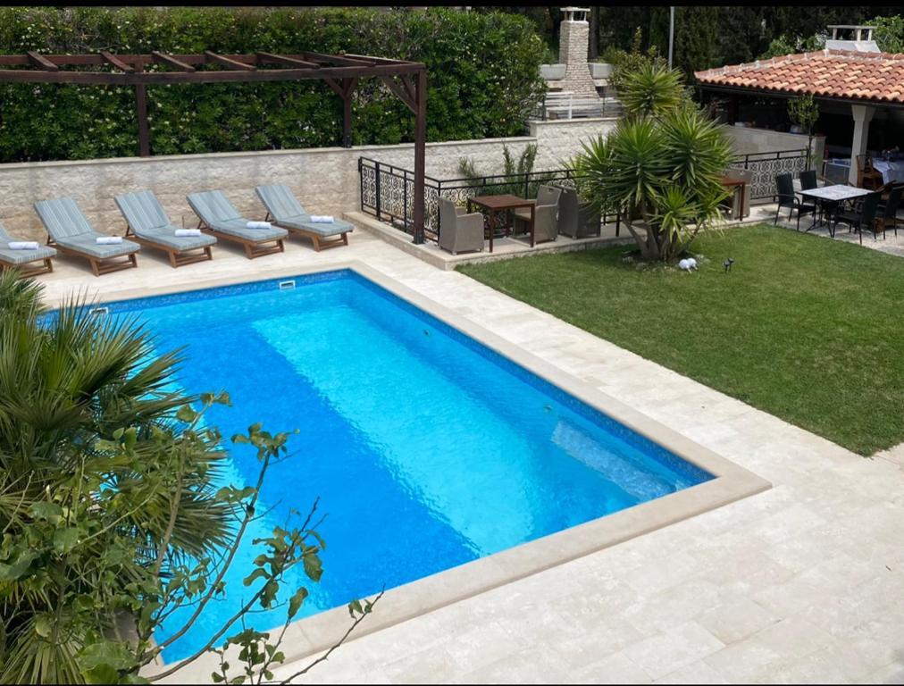 波尔地中海别墅的后院的游泳池,配有椅子和桌子