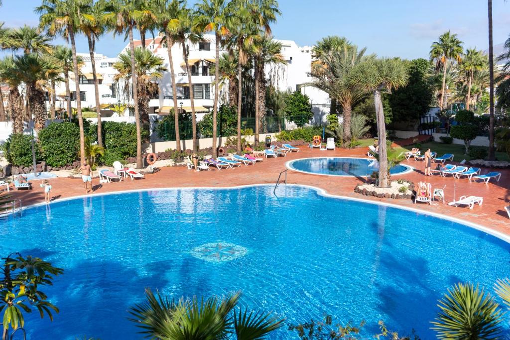 美洲海滩El Dorado 114 luxury with full air-conditioning的一座棕榈树大型游泳池和一座建筑