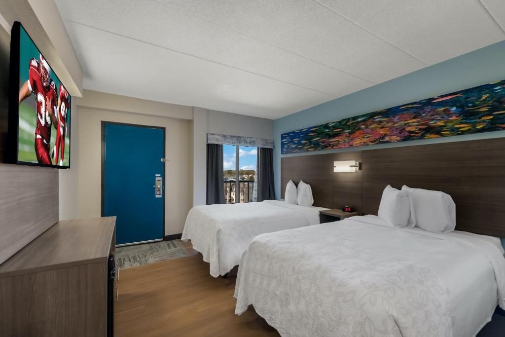 弗吉尼亚海滩Red Roof PLUS & Suites Virginia Beach - Seaside的酒店客房设有两张床,墙上挂有绘画作品