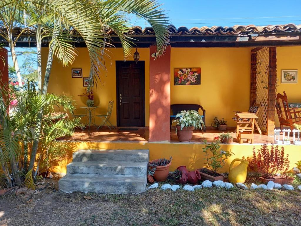 科马亚瓜Magnificent Private Room Near Airport #1的黄色的房子,有棕榈树和门廊