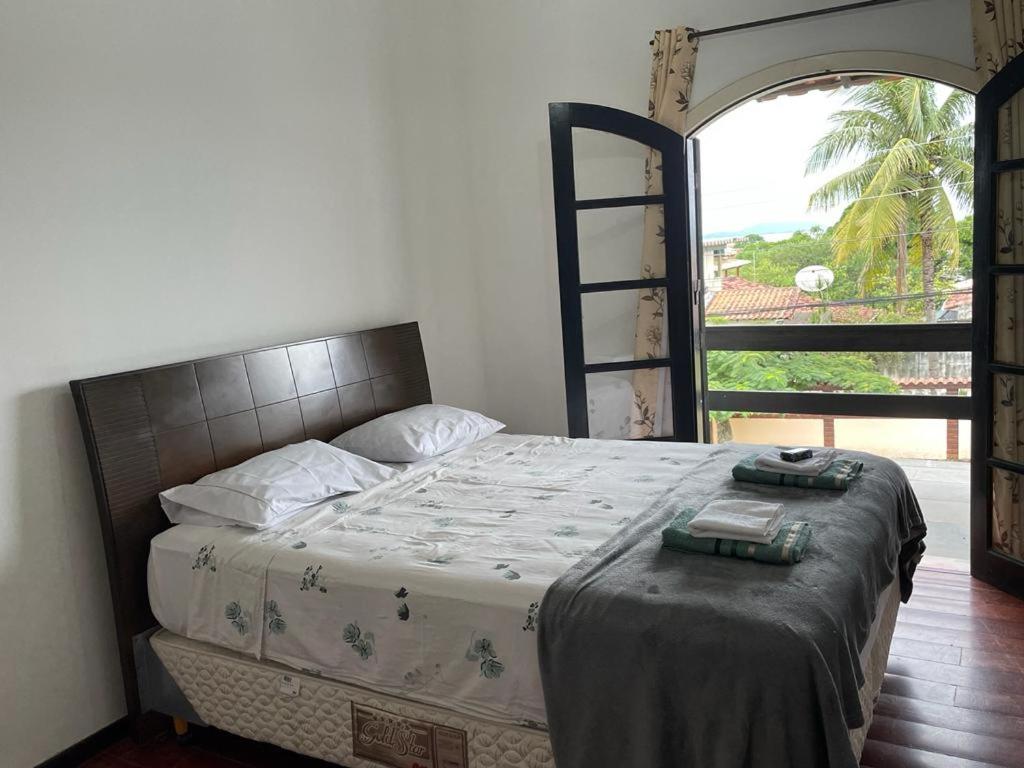 大伊瓜巴A Casa para a sua Família em Iguaba Grande, até 9 pessoas的一间卧室设有一张床和一个大窗户