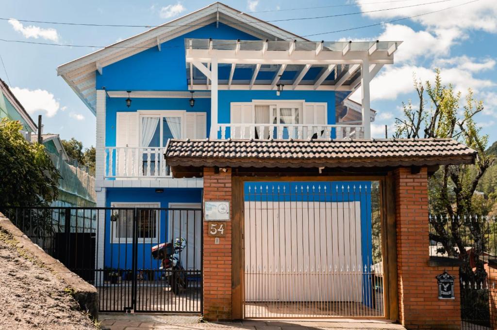 格拉玛多Casa da bela Vista的蓝色的房子,设有门和栅栏