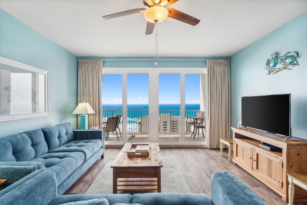巴拿马城海滩Sea-Renity at Laketown Wharf #1607 by Nautical Properties的客厅配有蓝色的沙发和平面电视。