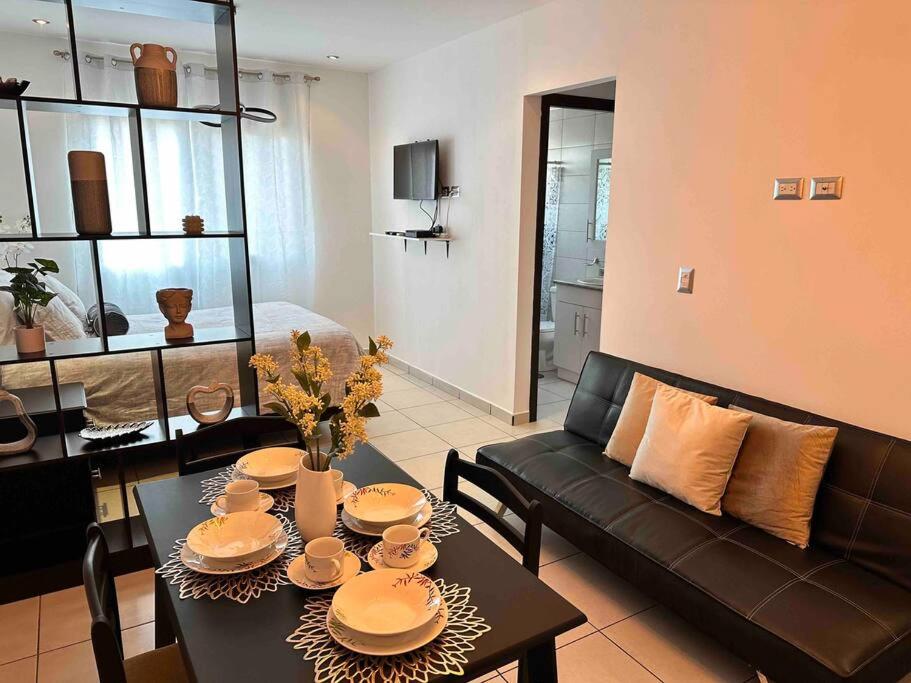 特古西加尔巴Monoambiente Apart-Studio的客厅配有桌子和黑色沙发