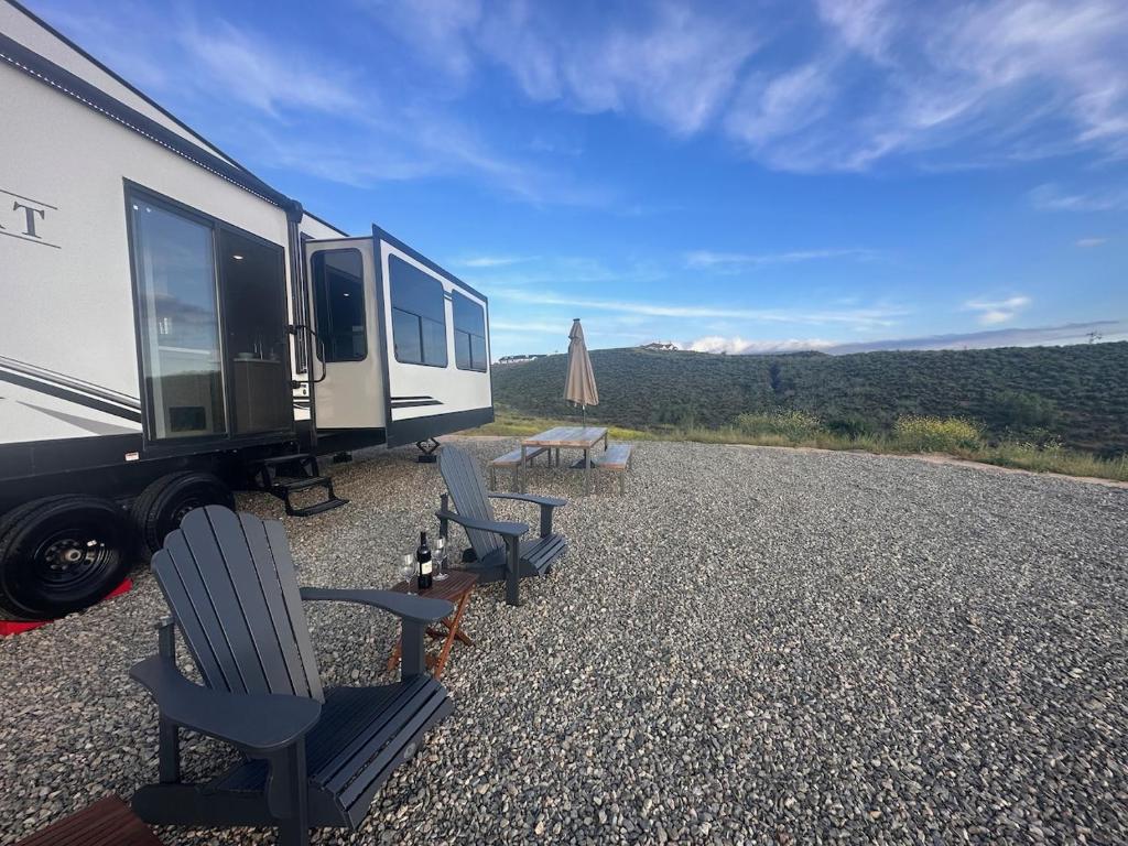 蒂梅丘拉Temecula Hilltop View Glamping Next To Wineries的配有两把椅子、一张桌子和一张野餐桌的走廊