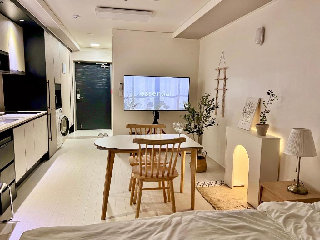 大邱Mi Stay - StarBnB branch的厨房以及带桌椅的起居室。