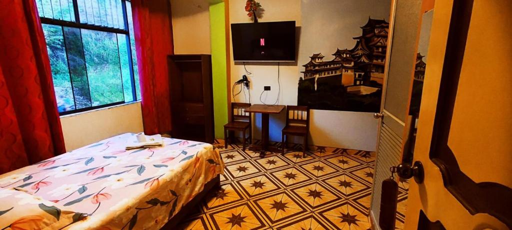廷戈玛丽亚HOSPEDAJE EL CANTARO的一间卧室配有一张床、一张桌子和一个窗户。