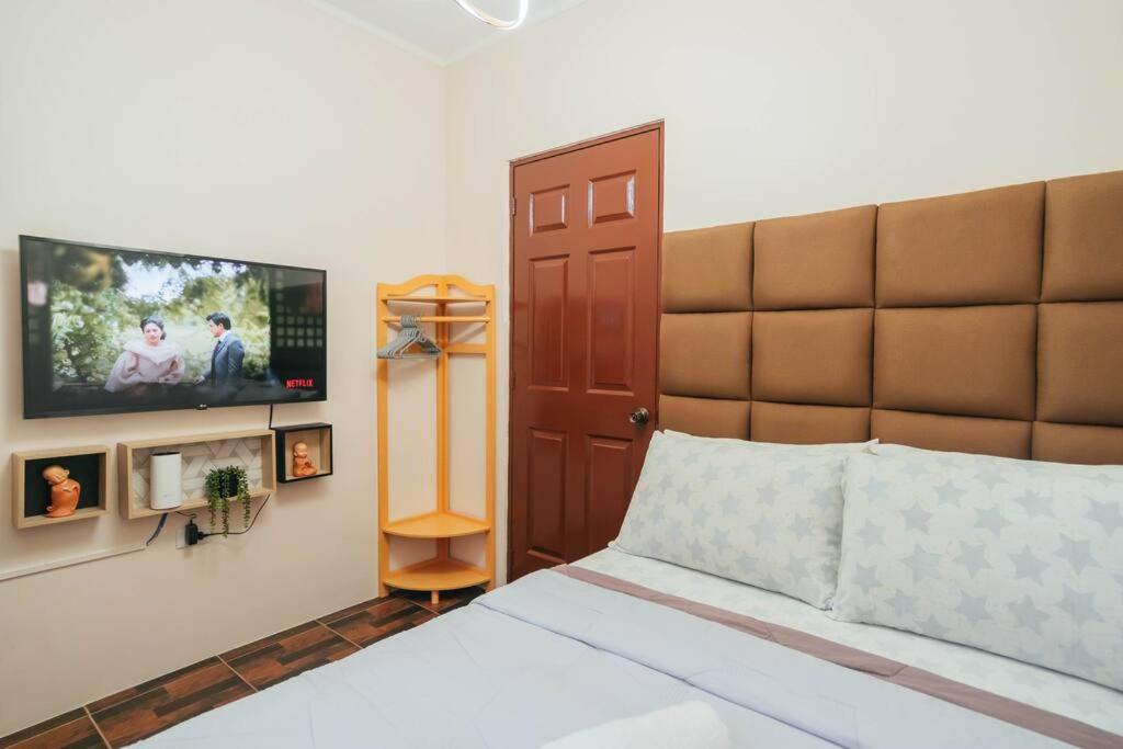 八打雁Cozy BNB - Unit G的一间卧室配有一张床和一台平面电视