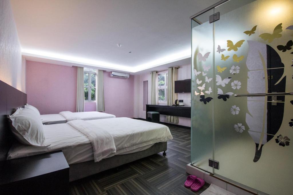 北赖S Hotel Seberang Jaya的一间卧室设有一张床和玻璃墙