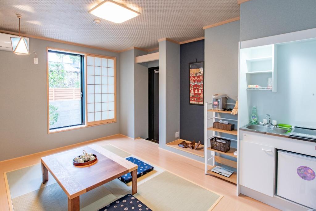 ShimmachidōriKyoto KaedeHotel Kamogawa的客厅配有桌子和窗户