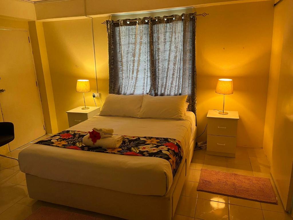 南迪Libby's Vacation Rental 2 Bed Home 1-4 Guests的一间卧室配有一张床、两盏灯和一个窗户。