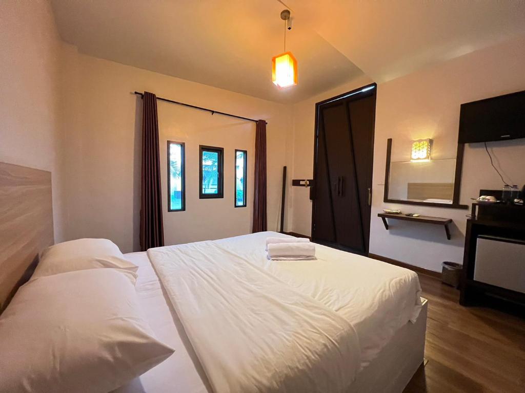 Ban Mae Kham Lang WatThe Green Season Resort的卧室配有白色的床和电视。