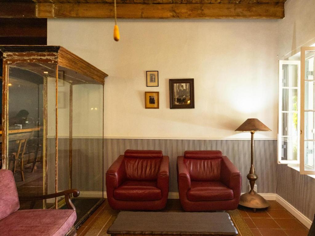 KlaarstroomKlaarstroom Hotel的客厅配有2把红色椅子和1盏灯