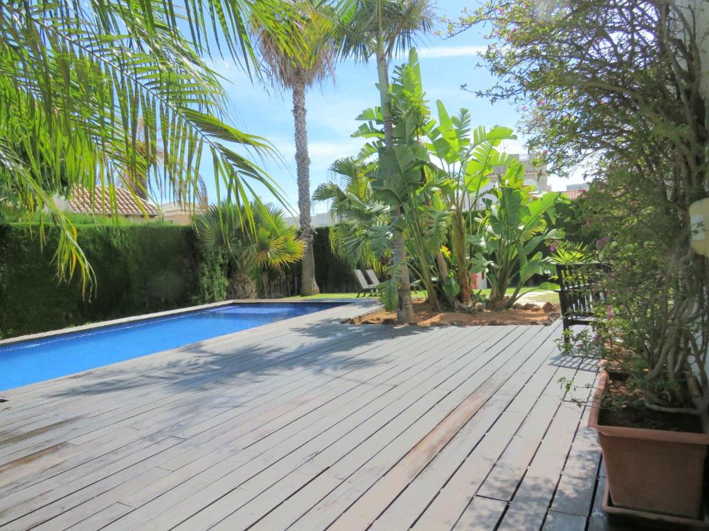 甘迪亚Casa Azahar y Casa Buganvilla的后院设有木甲板和游泳池