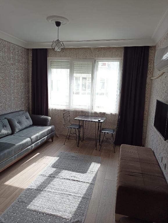 安塔利亚Konyaaltı Tunç Apart的客厅配有沙发和桌子