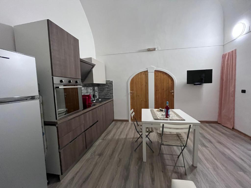 罗迪-加尔加尼科Casa vacanze la volta的厨房配有白色桌子和白色冰箱。
