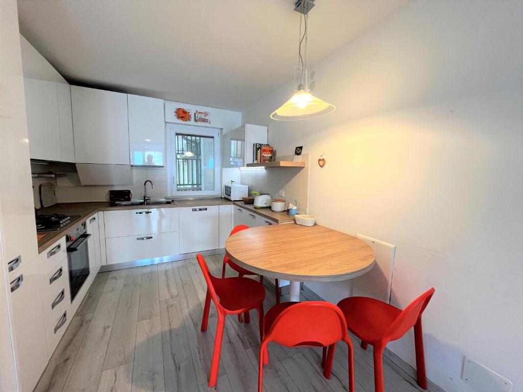 格拉多Nettuno的厨房配有木桌和红色椅子