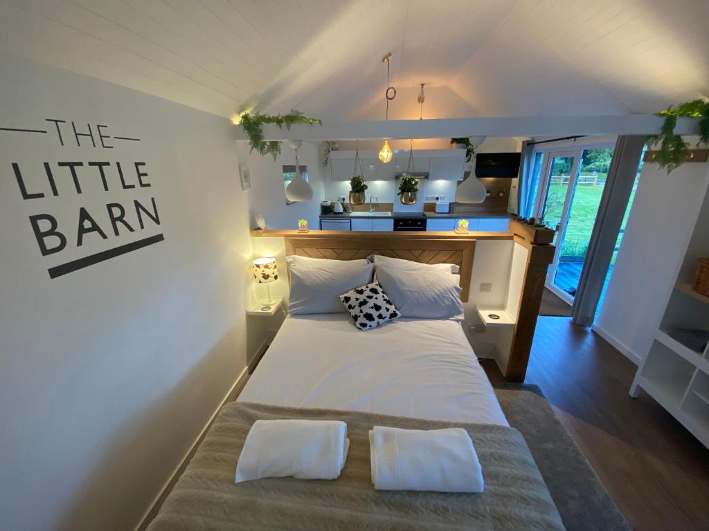 HoxneThe Little Barn的卧室配有一张带两个枕头的大白色床