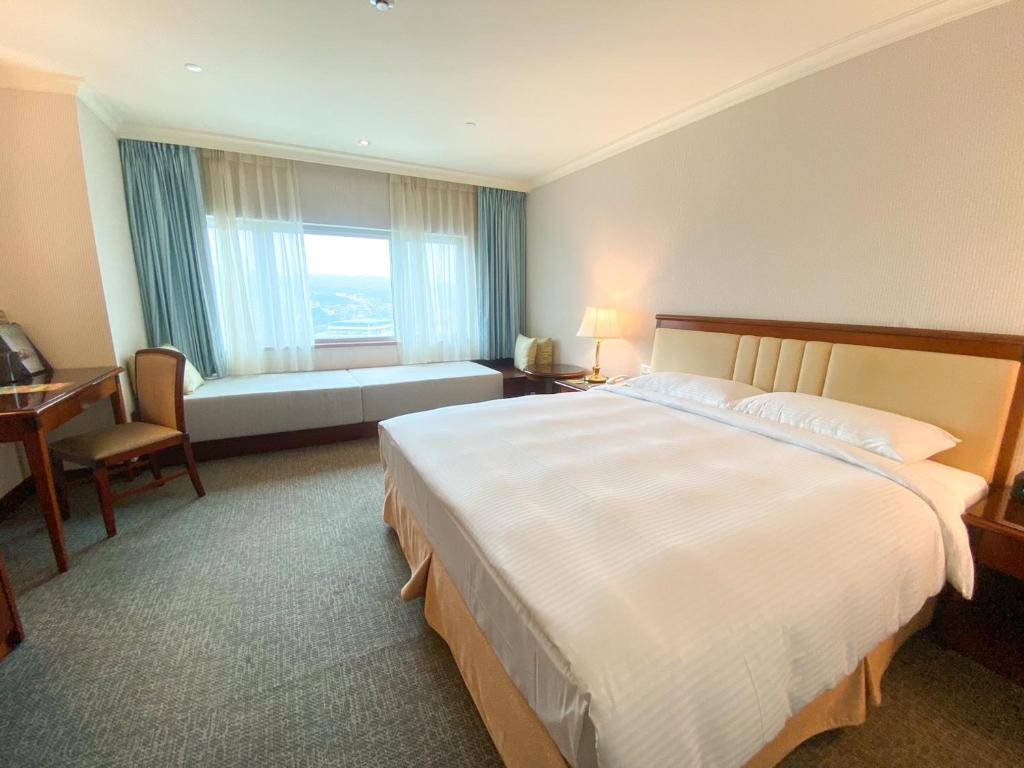 基隆长荣桂冠酒店 - 基隆的一间设有大床和窗户的酒店客房