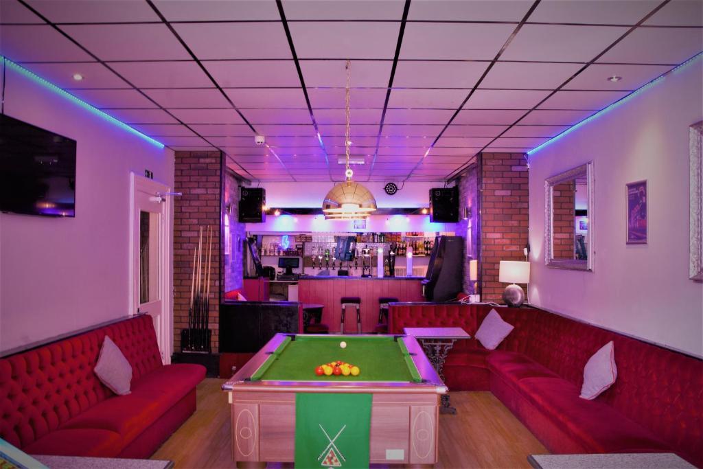 布莱克浦MyRoomz Silver Strand Hotel的一间酒吧,配有红色的沙发和台球桌