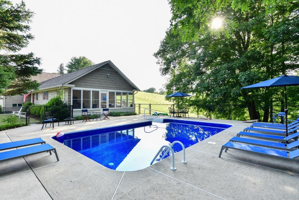 WashingtonOld Litchfield, Washington CT的一个带滑梯和蓝色长椅的游泳池
