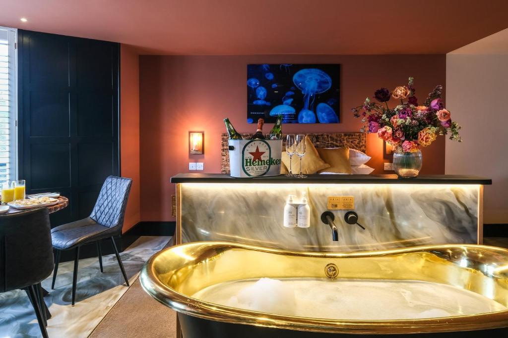 鲍内斯温德米尔Craig Walk Suite的一个带桌子的房间内的金色浴缸