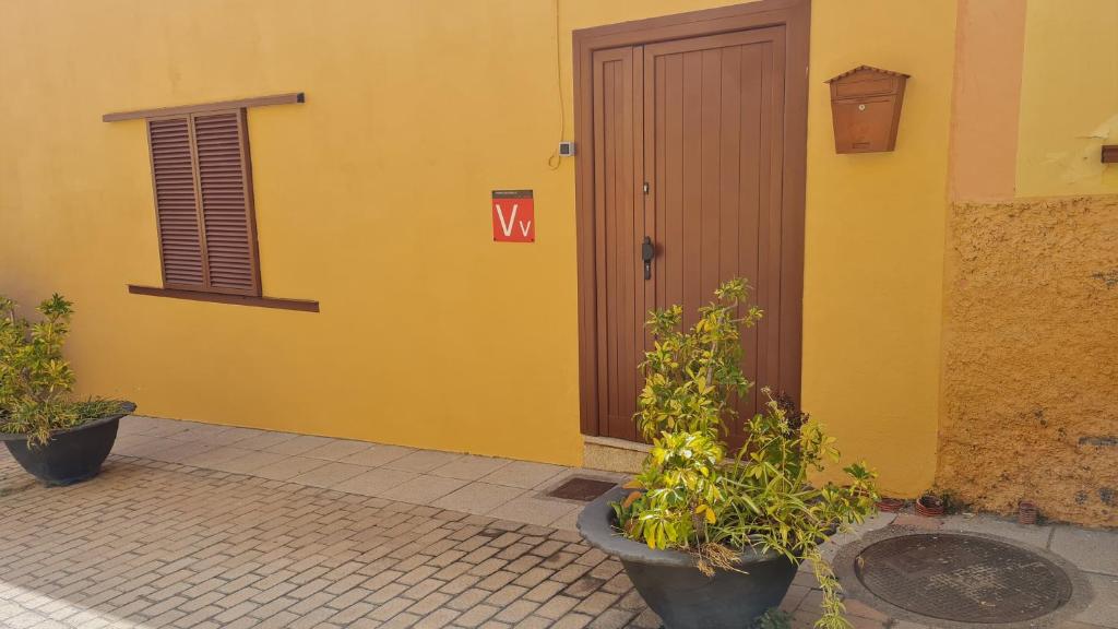 阿古伊梅斯Casa Mamatita的黄色的建筑,有门,上面有标志