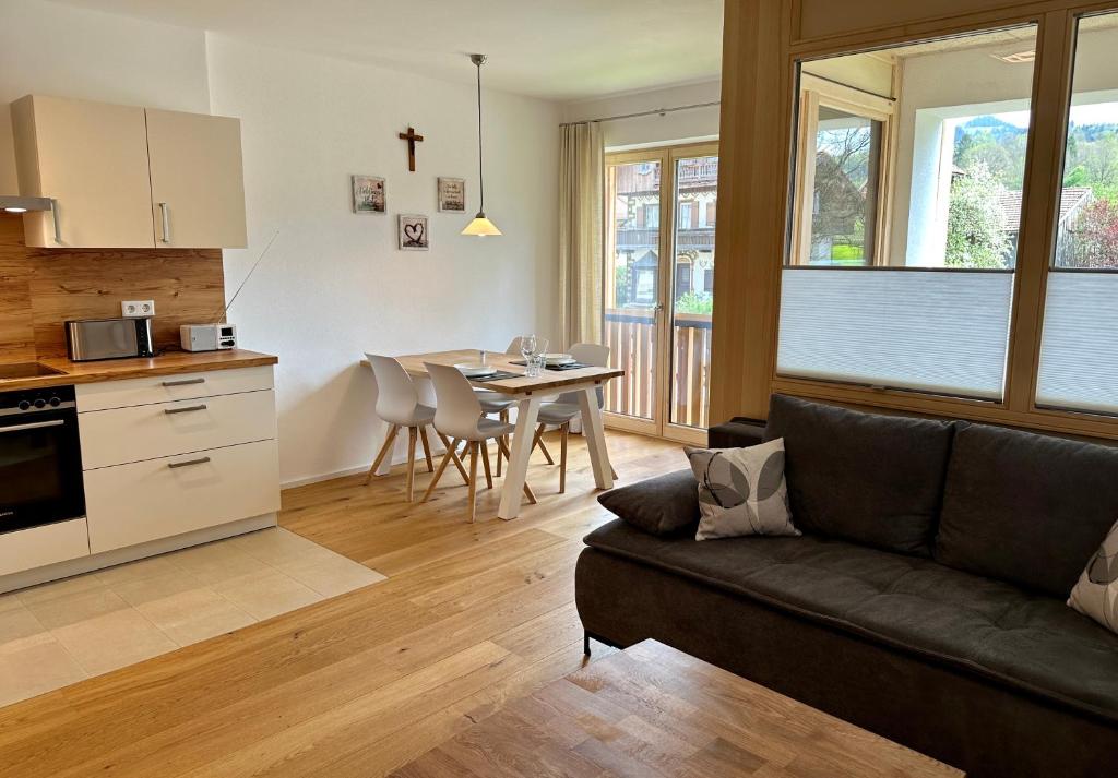菲施巴豪Apartment Breitensteinblick - wandern, radeln und Mehr的带沙发的客厅和带桌子的厨房