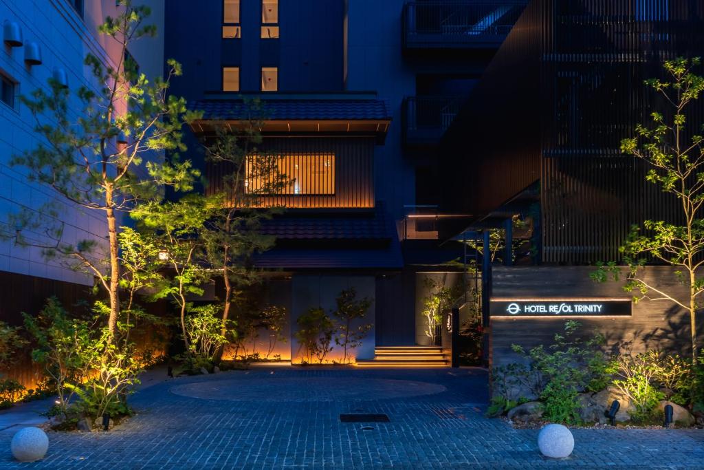 大阪Hotel Resol Trinity Osaka的一座晚上有庭院的建筑