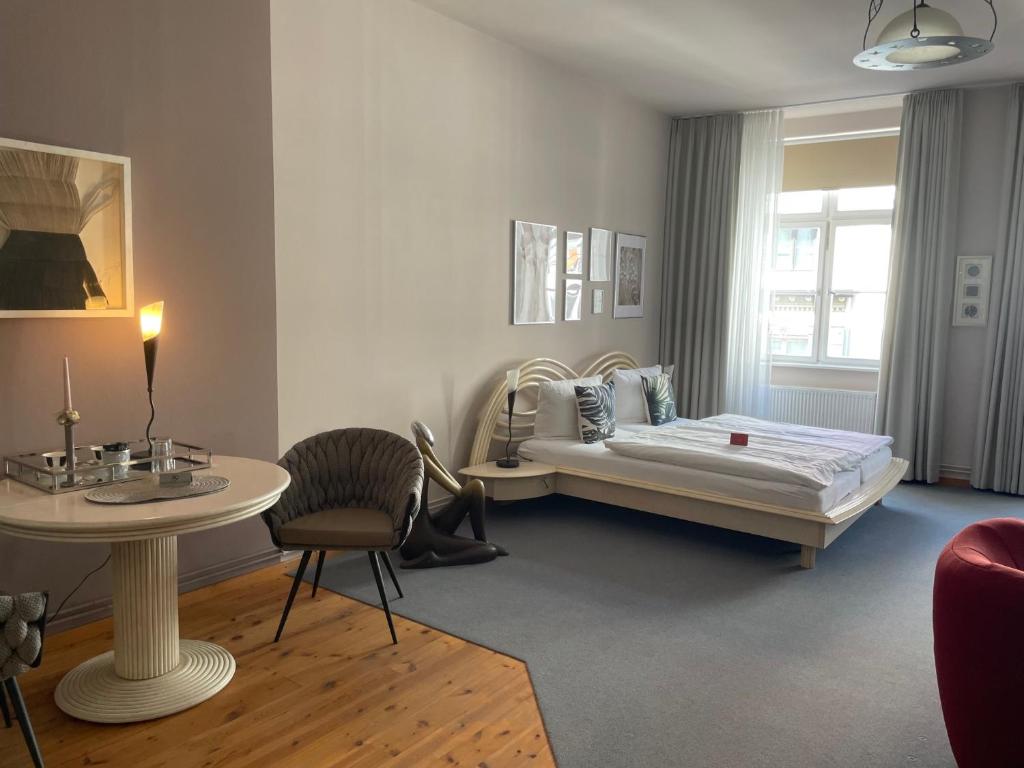 施特拉尔松德豪斯沃弗卡纳酒店的卧室配有1张床和1张桌子及椅子