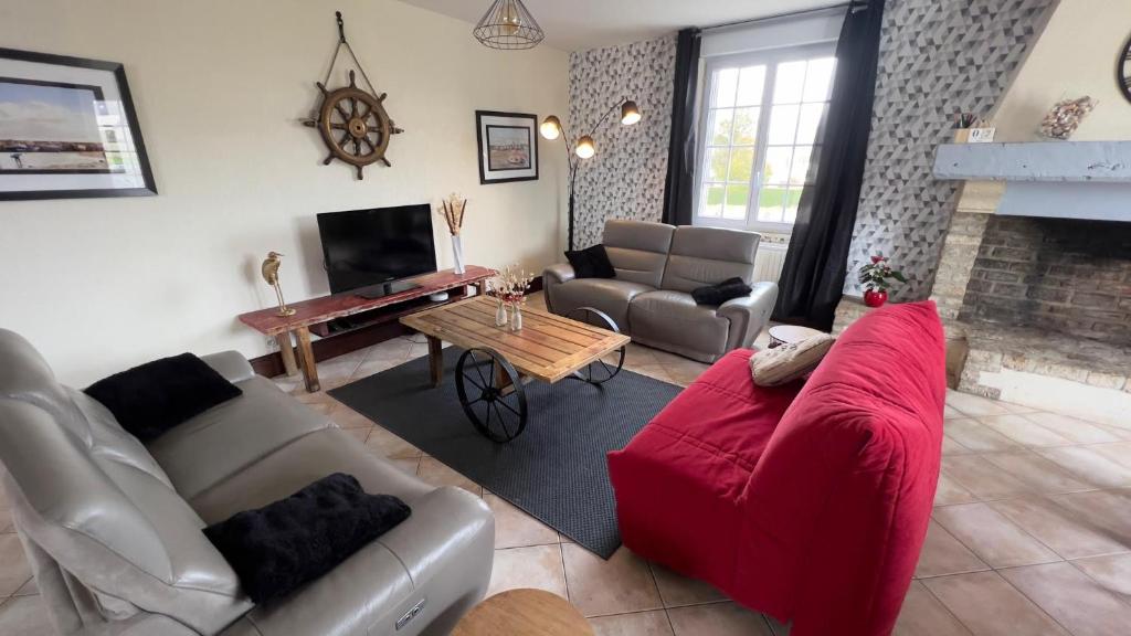 Saint-Hilaire-PetitvilleGrenouilles et coquillages的客厅设有红色的沙发和壁炉
