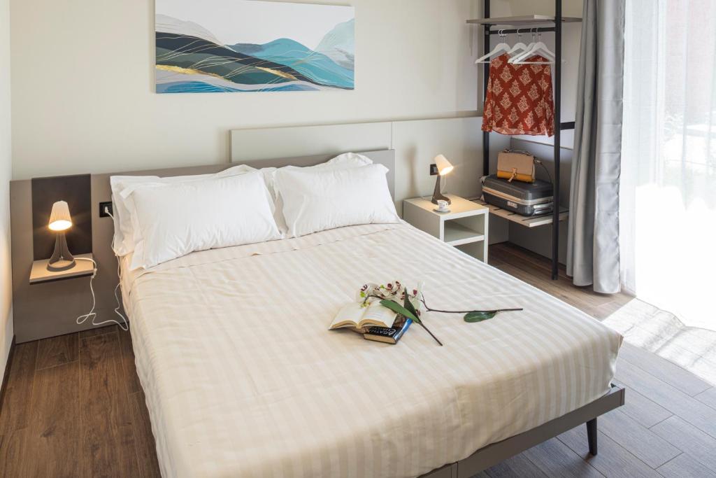 阿尔巴CASCINA SANT'ANTONIO的一间卧室,配有一张带书籍和鲜花的床