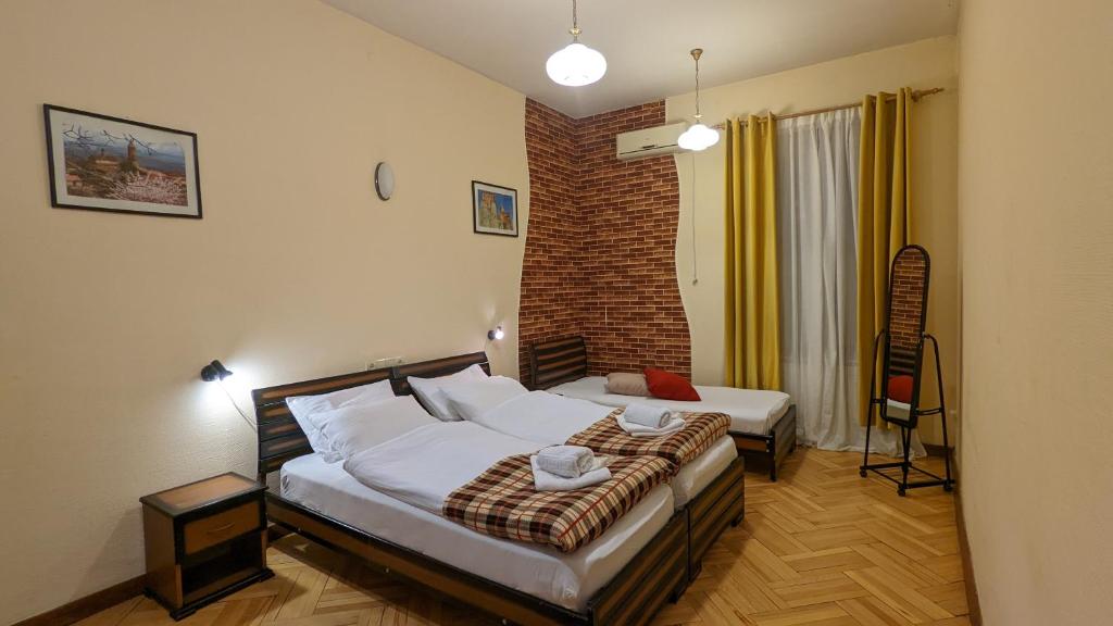 第比利斯Guesthouse Kartli的一间卧室设有两张床和砖墙
