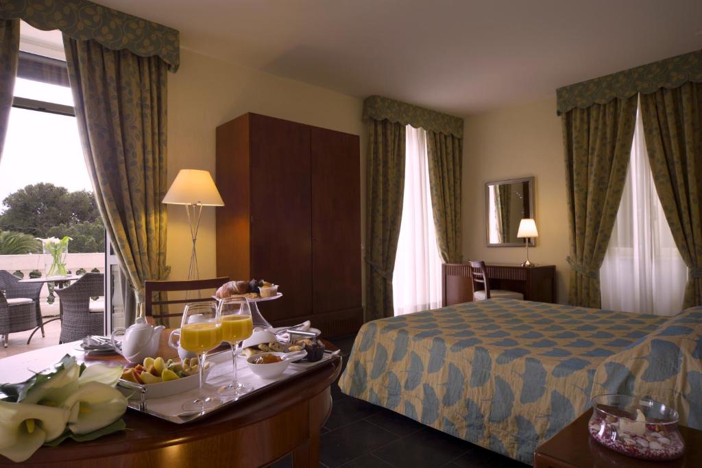 斯波托尔诺皇家别墅酒店的一间酒店客房,配有一张床和一盘食物