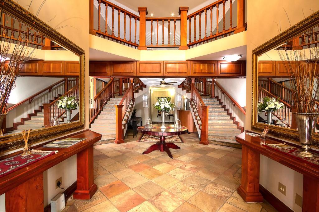 逊邱伦Leopardsong Manor的大房间设有楼梯和桌子