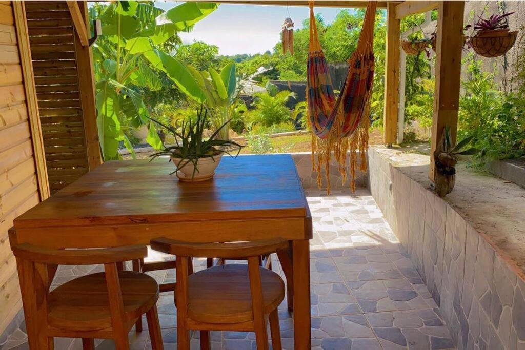 圣弗朗索瓦Banana EcoLodge的一个带窗户的庭院里的一张木桌子和椅子