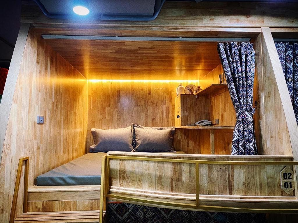 河江Sky Homestay Ha Giang的木墙客房的一张床位