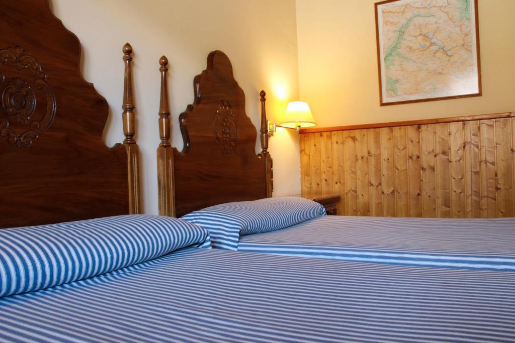 维耶拉德拉瓦尔酒店的一间卧室配有两张蓝色和白色条纹的床