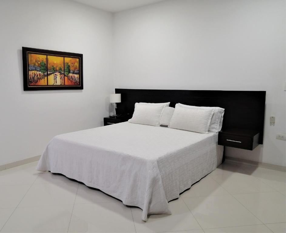 辛塞莱霍Hotel Panorama的一间卧室配有一张白色的床和黑色床头板