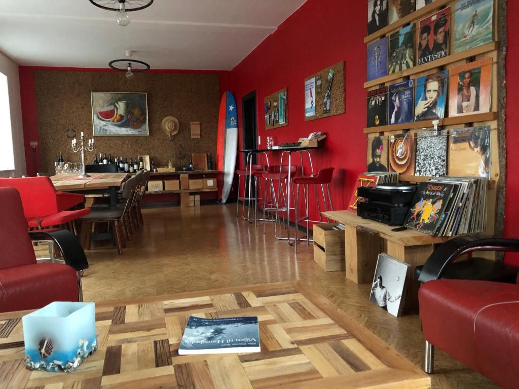 汉斯特霍尔姆La Ola的客厅设有红色的墙壁和桌椅
