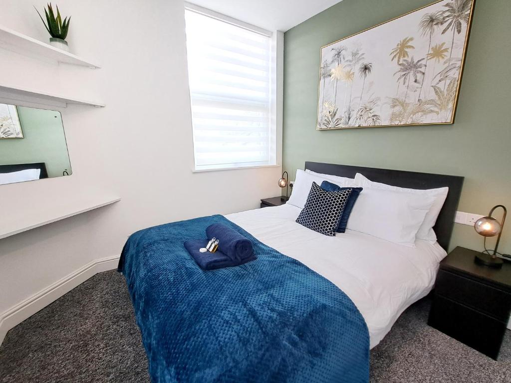 沃特福德Bright 3 Bed Apartment With Terrace, Free Parking!的一间卧室配有一张带蓝色毯子的床