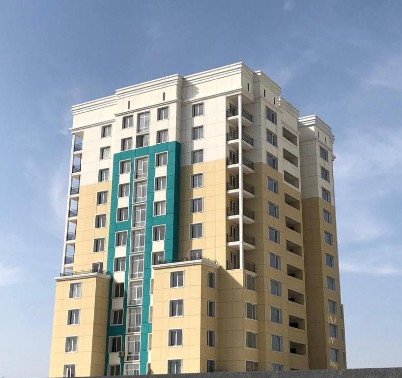 TürkistanЭлитная новая квартира в Туркестане 2的一座高大的公寓楼,后面有蓝色的天空