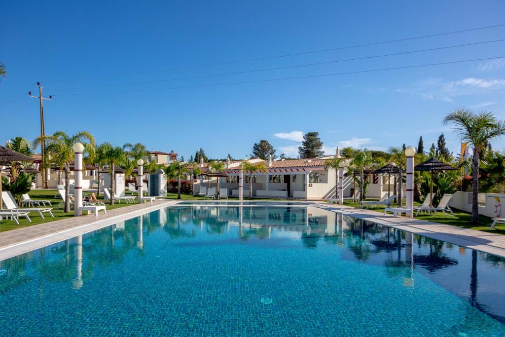费拉古多Brícia Du Mar Boutique Hotel的度假村内的大型蓝色游泳池