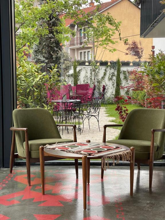 普里什蒂纳Etnomania Boutique Hotel的客房设有两把椅子和一张桌子,以及一个庭院。