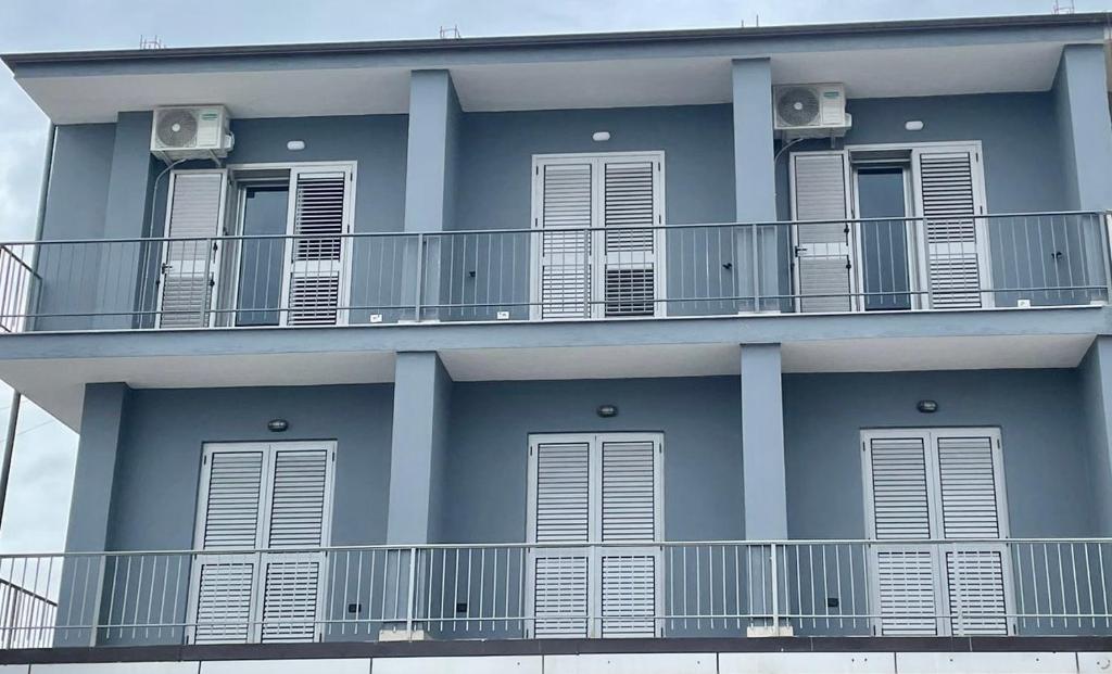 迪夫亚卡H&A Guest House的蓝色的建筑,设有白色的阳台和窗户